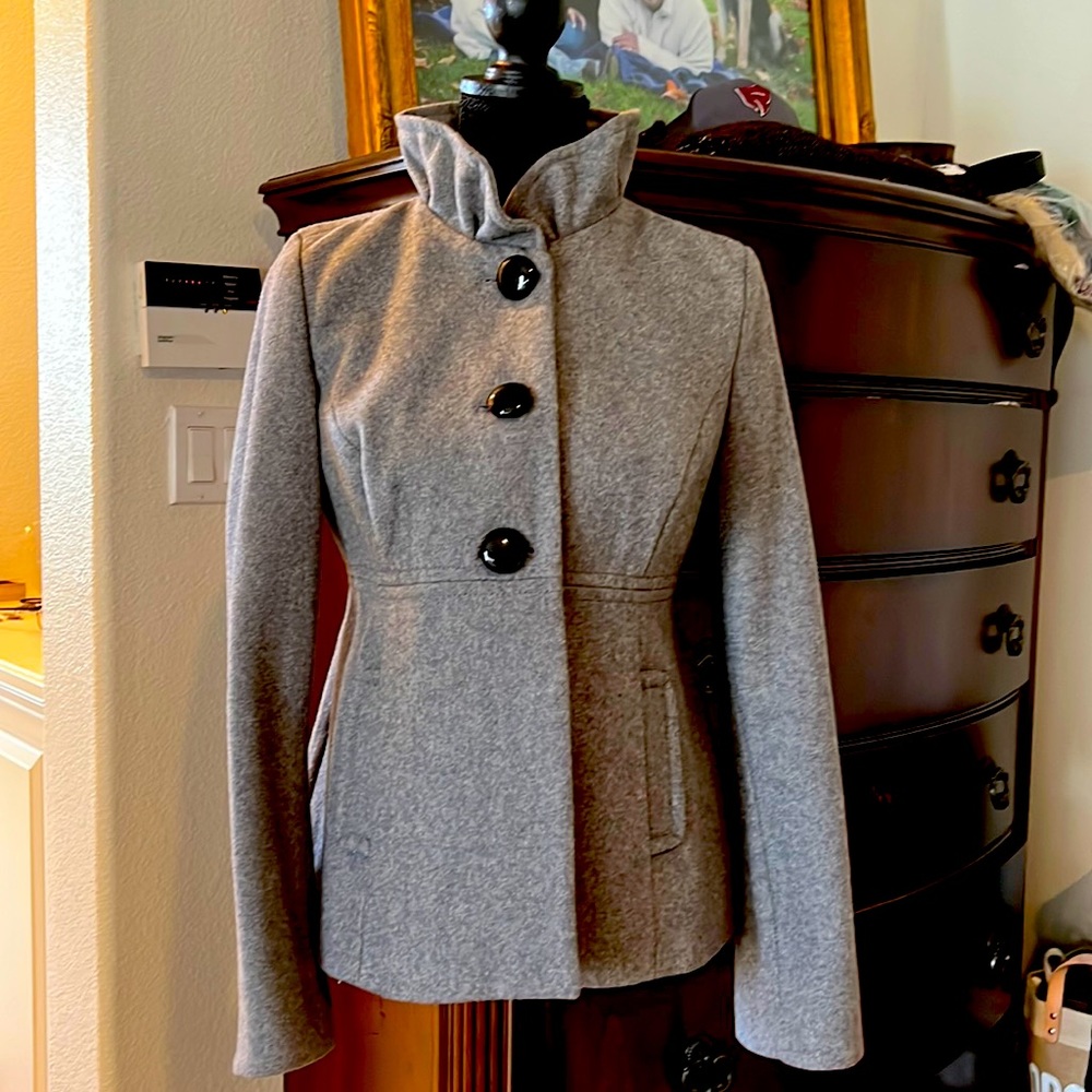 Waist length wool coat. Stand up ruffle collar, button detail on the back.